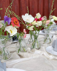 Åkerblomster som pynt på bord dekket til fest