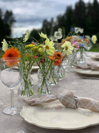 Festpyntet bord med småvaser og åkerblomster