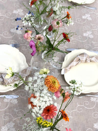 Festbord dekket på med åkerblomster i små vaser